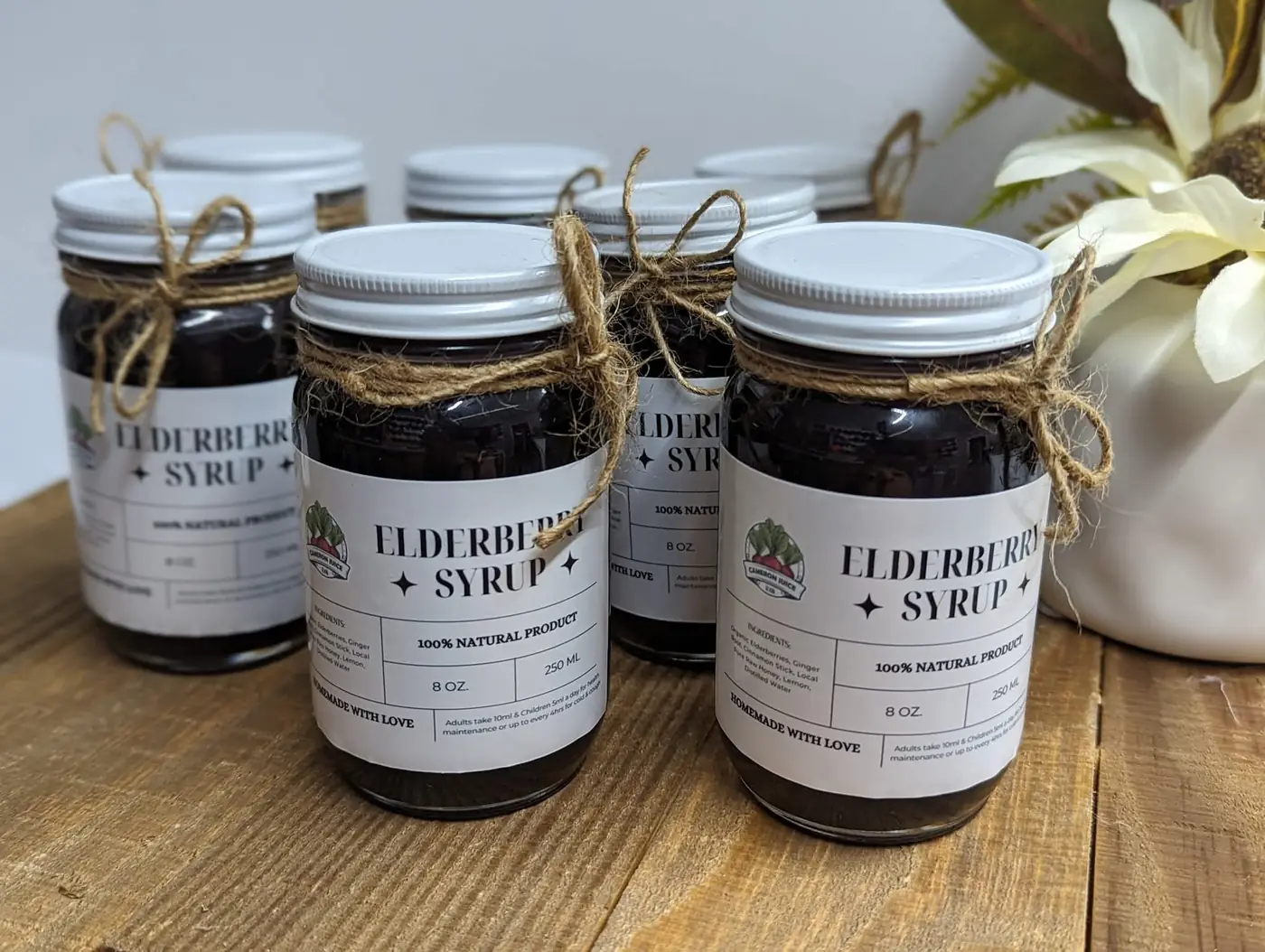 Jars of Cameron Juice Elderberry Syrup tied with twine bows